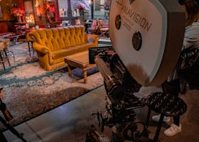 A vintage Panavision camera in a TV studio set with iconic Central Perk couch.