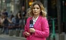 woman, news anchor, reporter, pink suit, standing, speaking, reportage, interview, street, urban, city